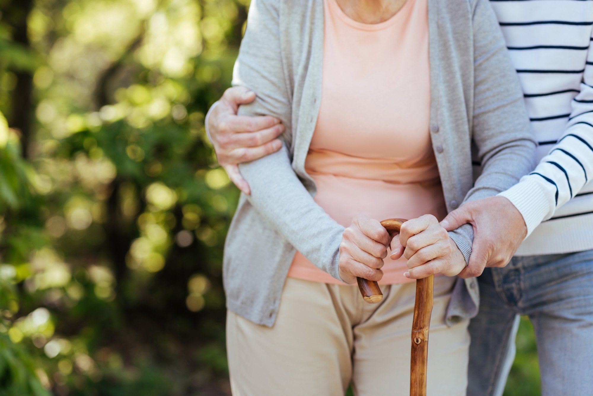 A physical therapist helps an older adult with a supported back and core exercise