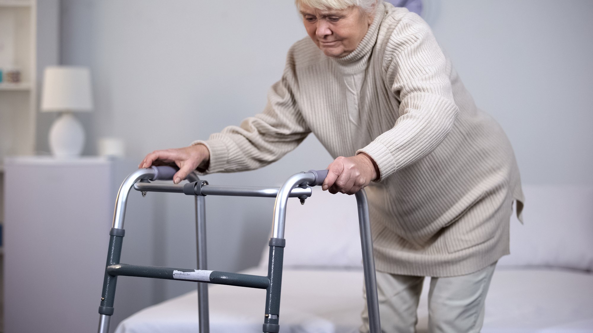 A physical therapist guides an older adult through a standing strength exercise