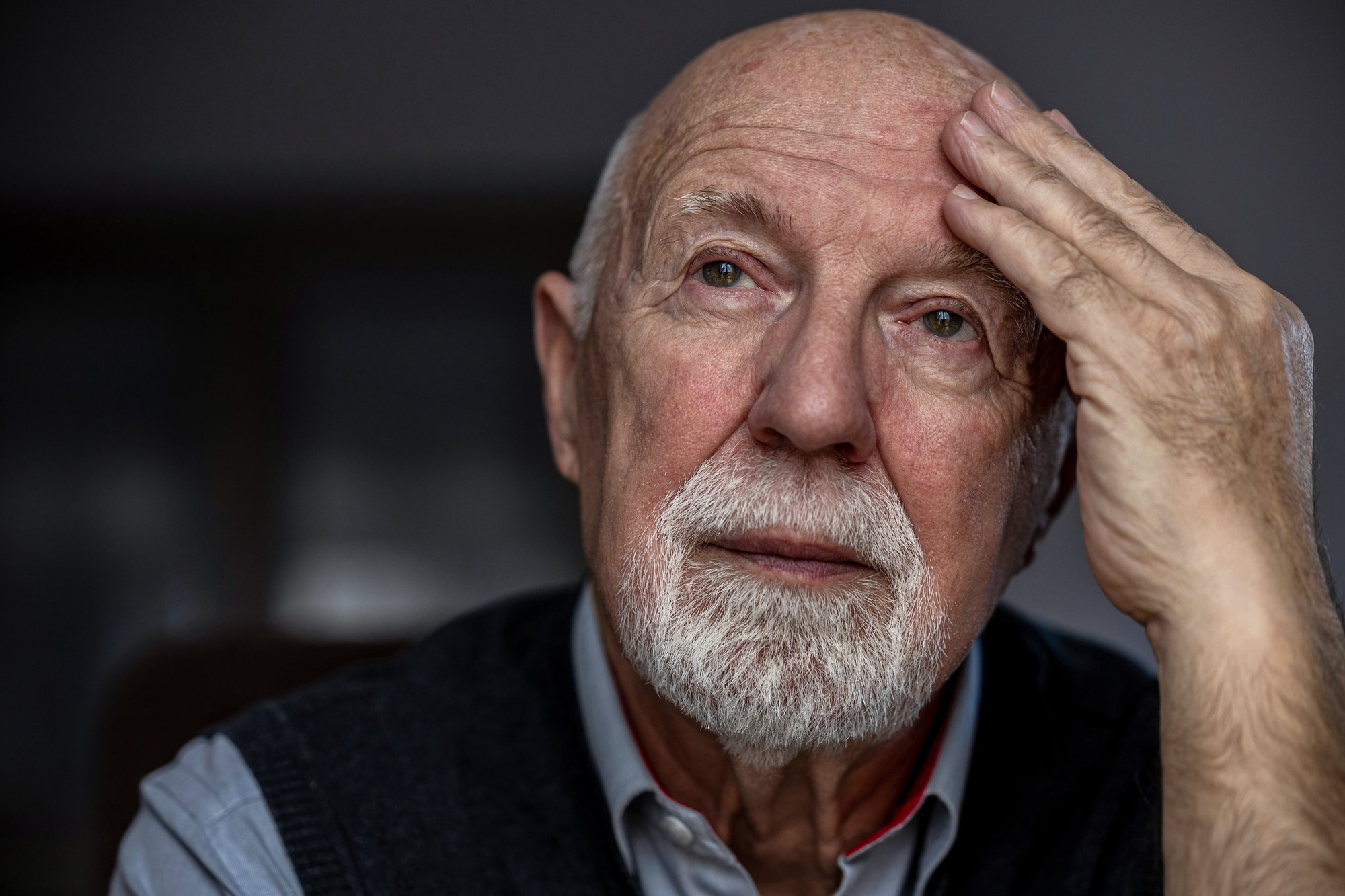 An older man practices walking with the support of a physical therapist