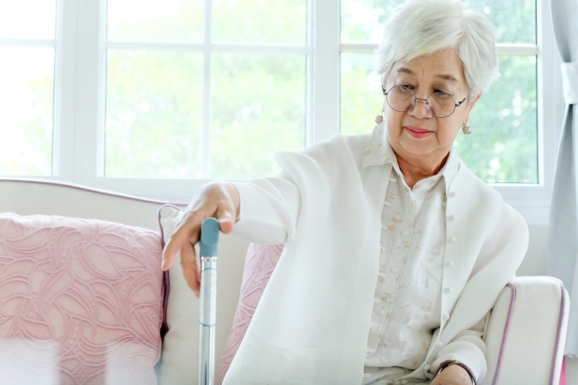 A physical therapist supports an older adult during a seated-to-standing exercise