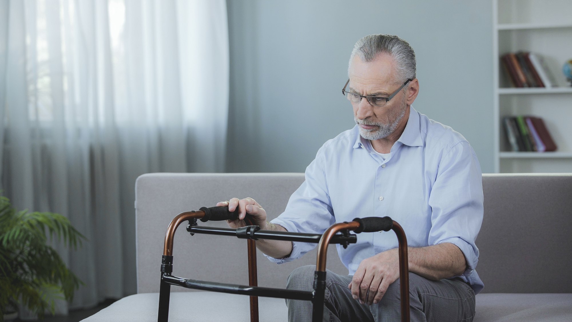 Close-up of an older adult and a caregiver with hands clasped together in support
