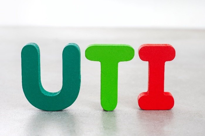 Wooden block letters spelling UTI in green and red