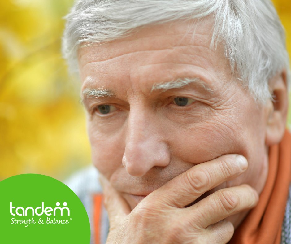 A pensive older man rests his hand on his chin